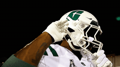 A Football Player Wearing A White Helmet With A Green X On It GIF