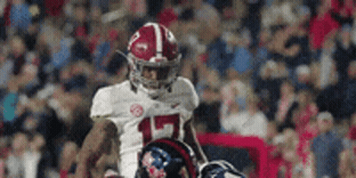 A Football Player Wearing A White Jersey With The Number 15 On It Is Running On The Field . GIF