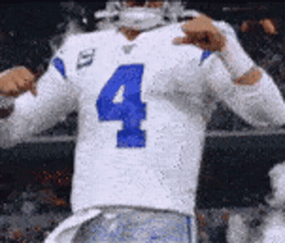 A Football Player Wearing A White Jersey With The Number Four On It Is Giving A Thumbs Up . GIF