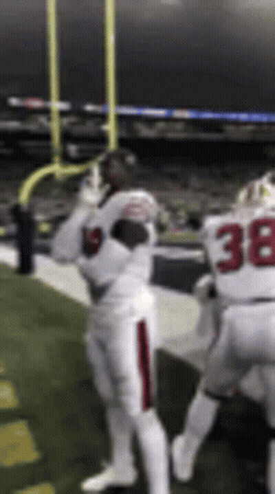 A Football Player Wearing A White Uniform With The Number 38 On It Is Standing On A Field . GIF