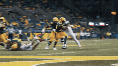 A Football Player Wearing A Yellow Jersey With The Number 28 On It Is Being Tackled GIF