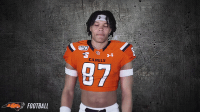 A Football Player Wearing An Orange Jersey With The Number 87 GIF