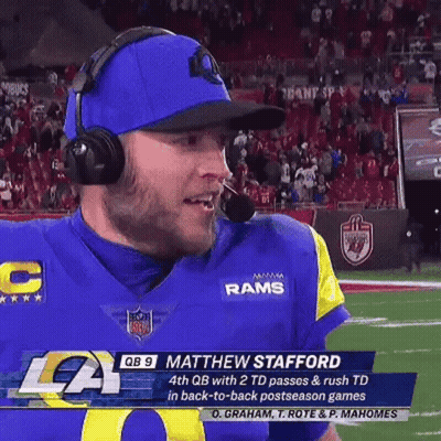 A Football Player Wearing Headphones And A Blue Hat Is On The Field . GIF