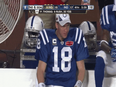 A Football Player Wearing Number 18 Sits On The Bench GIF