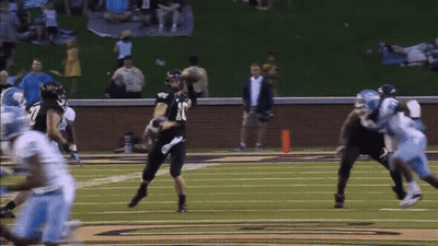 A Football Player Wearing Number 18 Throws The Ball GIF