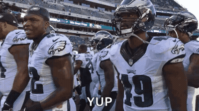 A Football Player Wearing Number 19 Stands In A Line GIF