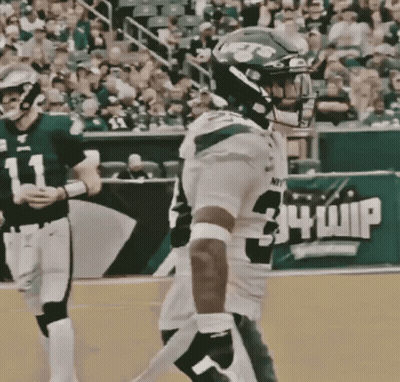 A Football Player Wearing Number 34 Whip Stands On The Field GIF