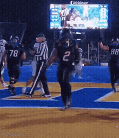 A Football Player Wearing The Number 2 Jersey Is Running On The Field GIF