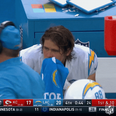 A Football Player Wipes His Nose With A Blue Towel During A Game GIF