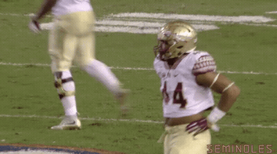 A Football Player With A Crop Top On Is Standing On The Field . GIF