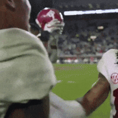 A Football Player With The Letter B On His Jersey Is Holding A Football GIF