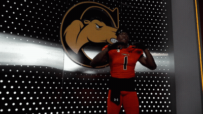 A Football Player With The Number 1 On His Jersey Stands In Front Of A Wall With Dots GIF