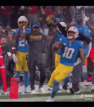 A Football Player With The Number 10 On His Jersey Is Running With The Ball GIF