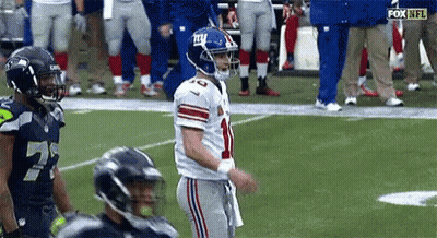 A Football Player With The Number 10 On His Jersey Is Standing On The Field . GIF