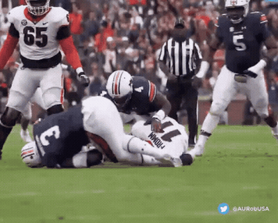 A Football Player With The Number 11 On His Jersey Is Being Tackled By Another Player . GIF