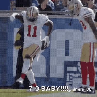 A Football Player With The Number 11 On His Jersey Is Jumping In The Air . GIF
