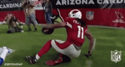A Football Player With The Number 11 On His Jersey Is Kneeling On The Field While Holding A Football . GIF