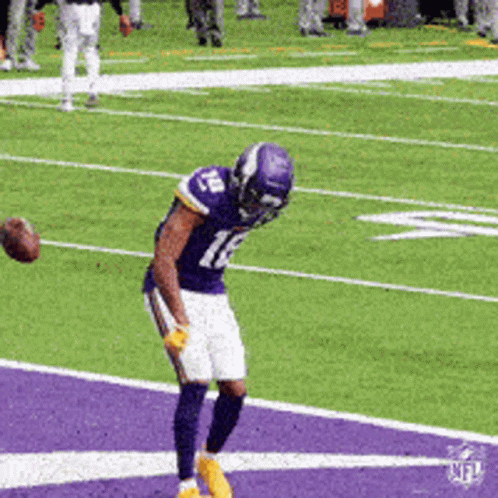 A Football Player With The Number 12 On His Jersey Catches A Ball GIF