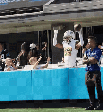 A Football Player With The Number 12 On His Jersey Catches A Ball GIF