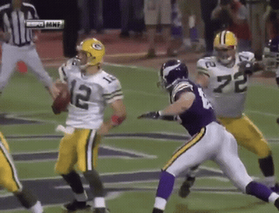 A Football Player With The Number 12 On His Jersey Is Being Tackled By Another Player GIF