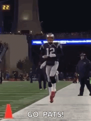 A Football Player With The Number 12 On His Jersey Is Running Down The Field GIF