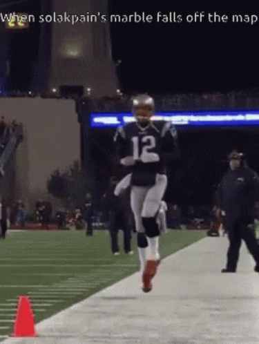 A Football Player With The Number 12 On His Jersey Is Running On A Field GIF