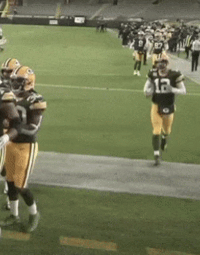 A Football Player With The Number 12 On His Jersey Is Running On The Field GIF