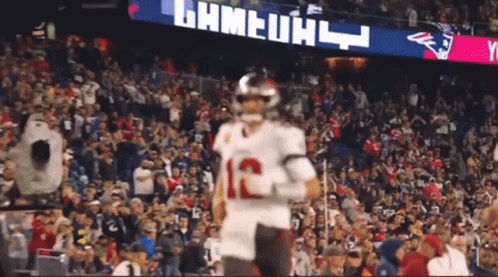 A Football Player With The Number 12 On His Jersey Is Running On The Field GIF