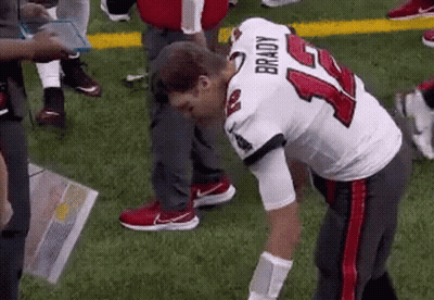 A Football Player With The Number 14 On His Jersey Is Kneeling Down On The Field . GIF