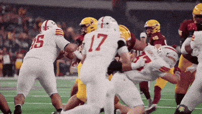 A Football Player With The Number 17 On His Jersey Is Being Tackled GIF