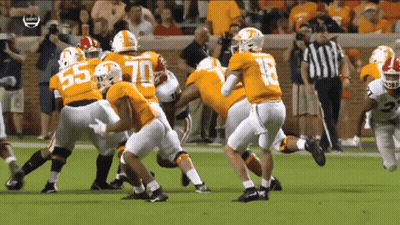 A Football Player With The Number 18 On His Jersey Is Being Tackled By Other Players GIF