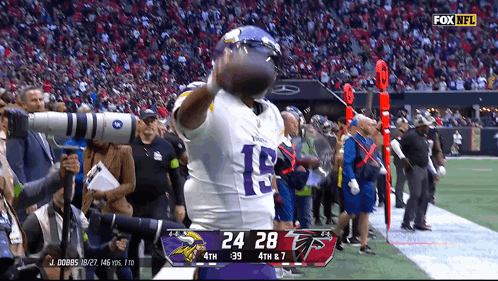 A Football Player With The Number 18 On His Jersey Is Holding A Football GIF