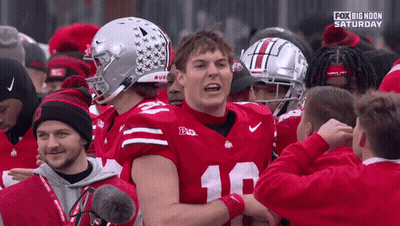 A Football Player With The Number 18 On His Jersey Is Surrounded By Other Players GIF