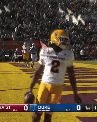 A Football Player With The Number 2 On His Jersey Is Holding A Ball GIF