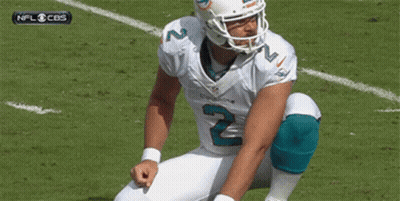 A Football Player With The Number 2 On His Jersey Is Squatting Down On The Field GIF