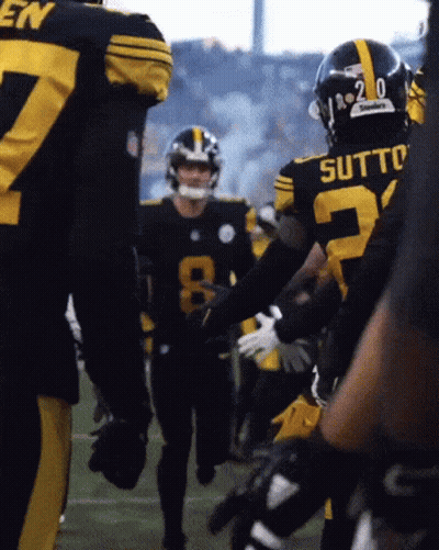 A Football Player With The Number 20 On His Helmet Is Talking To Another Player GIF