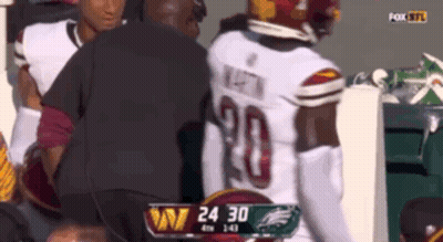 A Football Player With The Number 20 On His Jersey Is Being Helped By A Man GIF
