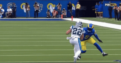 A Football Player With The Number 22 On His Jersey Is Being Tackled By Another Player On The Field . GIF