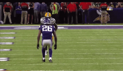 A Football Player With The Number 26 On His Jersey Stands On The Field GIF