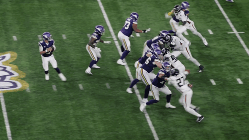 A Football Player With The Number 27 On His Jersey Is Being Tackled GIF