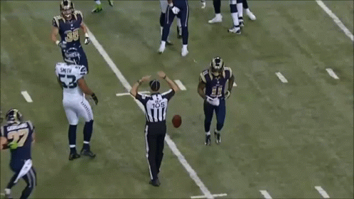 A Football Player With The Number 27 On His Jersey Is Laying On The Ground GIF