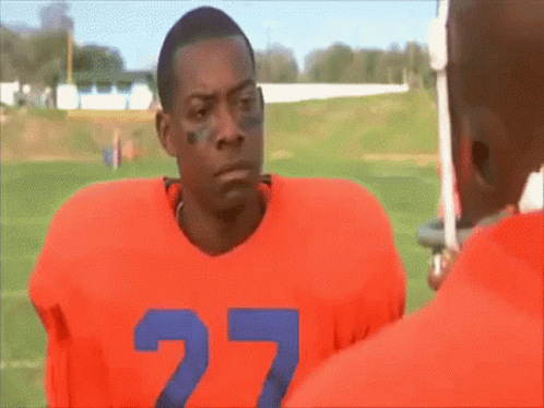 A Football Player With The Number 27 On His Jersey Is Standing On A Field . GIF