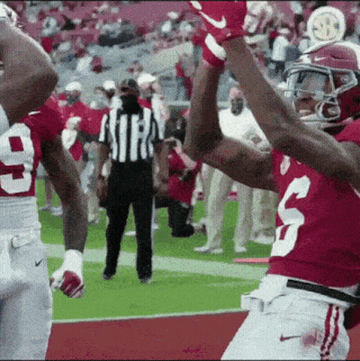 A Football Player With The Number 3 On His Jersey Is Giving A High Five To Another Player GIF