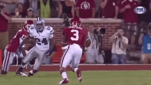 A Football Player With The Number 3 On His Jersey Is Running On The Field . GIF