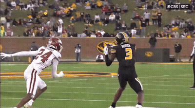 A Football Player With The Number 3 On His Jersey Is Trying To Catch A Pass From Another Player GIF