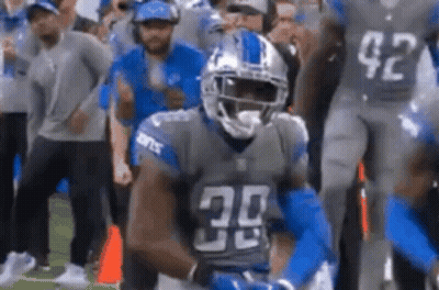 A Football Player With The Number 30 On His Jersey Is Standing On The Field . GIF