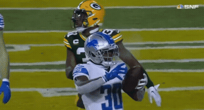 A Football Player With The Number 30 On His Jersey Is Trying To Catch A Ball . GIF