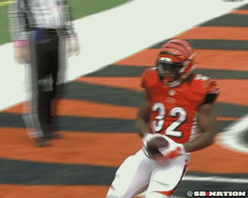 A Football Player With The Number 32 On His Jersey Is Running With The Ball GIF