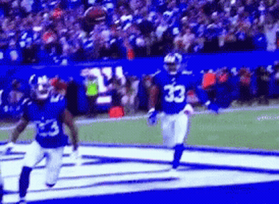 A Football Player With The Number 33 On His Jersey Is Running On The Field . GIF