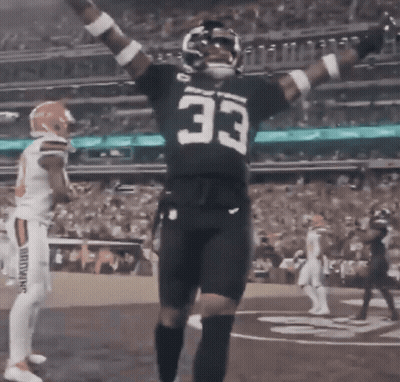 A Football Player With The Number 33 On His Jersey Stands On The Field GIF